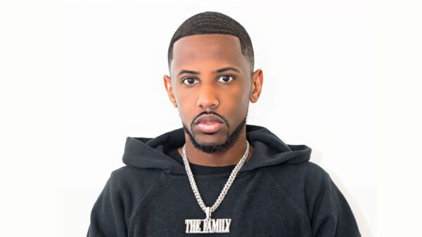 Fabolous with short, neatly styled hair and a trimmed beard wears a black hoodie and a silver chain necklace with a